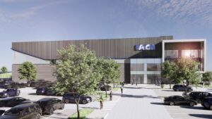 Exterior rendering of a modern office building with an Eaton sign, glass entrance, and surrounding trees and cars in a parking lot.